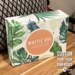 Custom printed packaging box with tropical leaf pattern and bold coral Mattie Rae branding.
